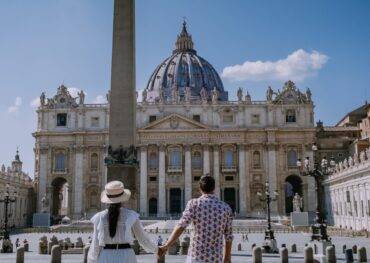 Egy pár áll kézenfogva a Szent Péter-bazilika előtt
