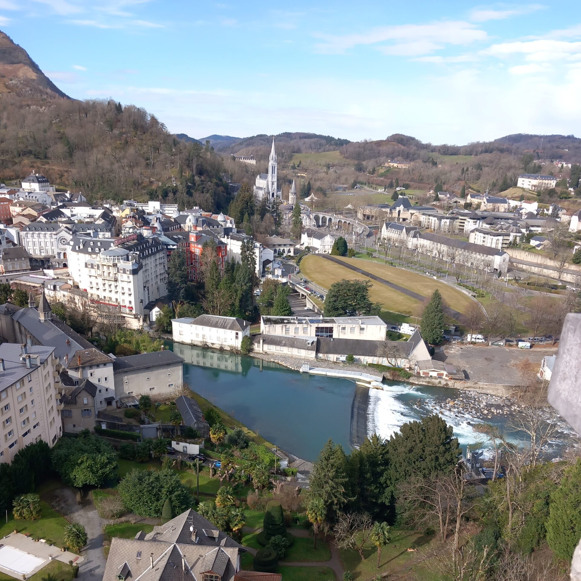 Látkép a lourdes-i várból a kegyhelyre egy késő téli napon