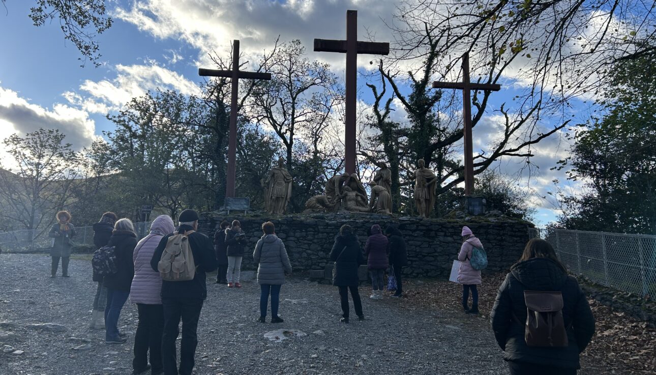Emberek néznek egy életnagyságú keresztrefeszítési jelenetet Lourdes-ban